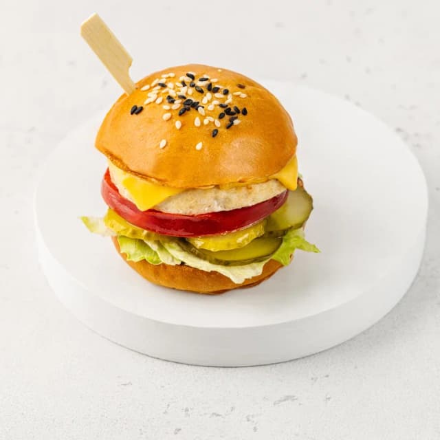 Бургер с нежной куриной котлеткой, сочным томатом и соусом гриль