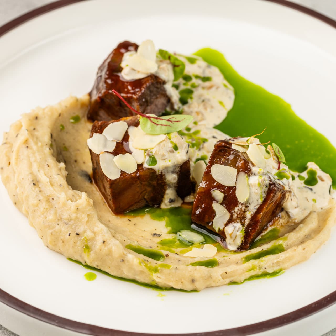 Говяжьи щечки с картофельно-трюфельным муссом, грибным соусом и зеленым маслом 