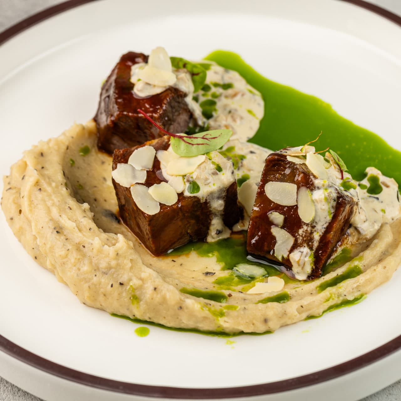 Говяжьи щечки с картофельно-трюфельным муссом, грибным соусом и зеленым маслом