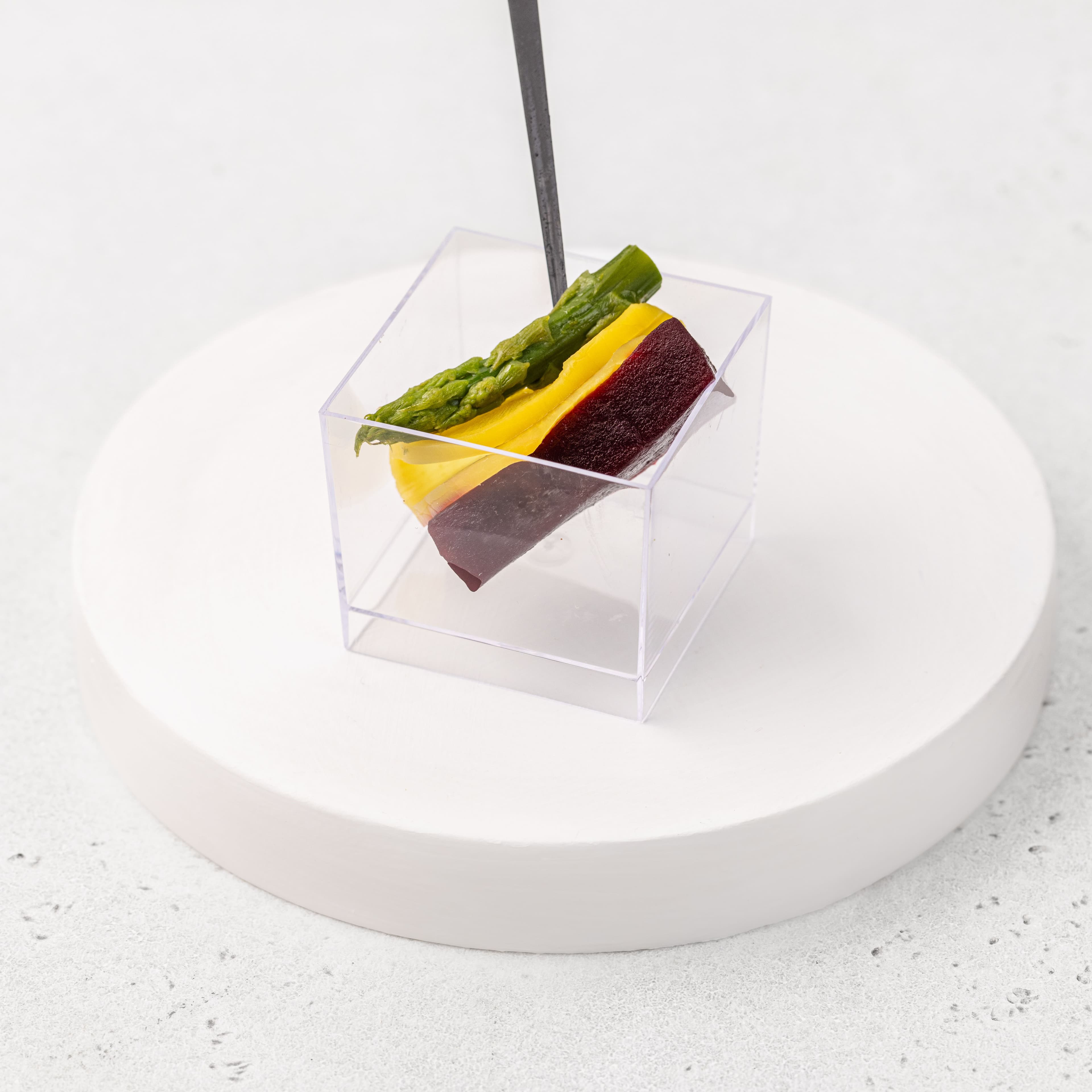 Спаржа с дайконом на прямоугольнике из свеклы