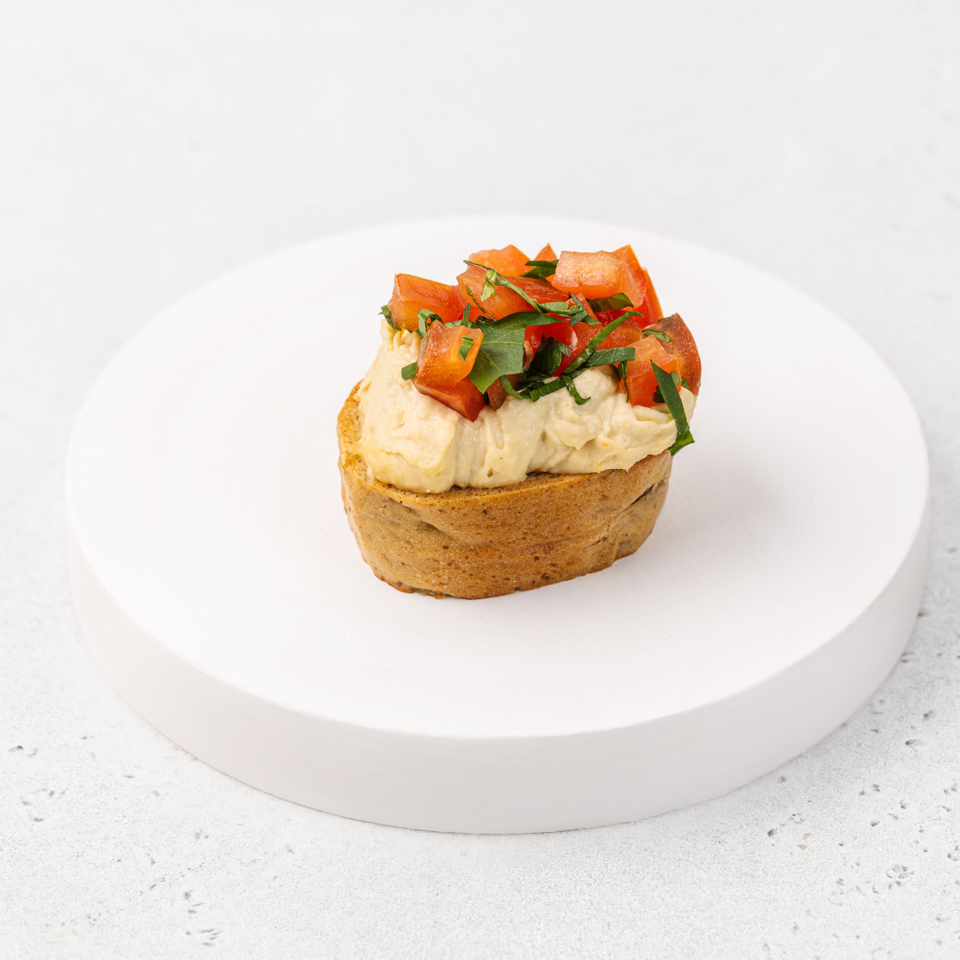 Брускетта с хумусом, томатами конкасе в заправке понзу и кинзой